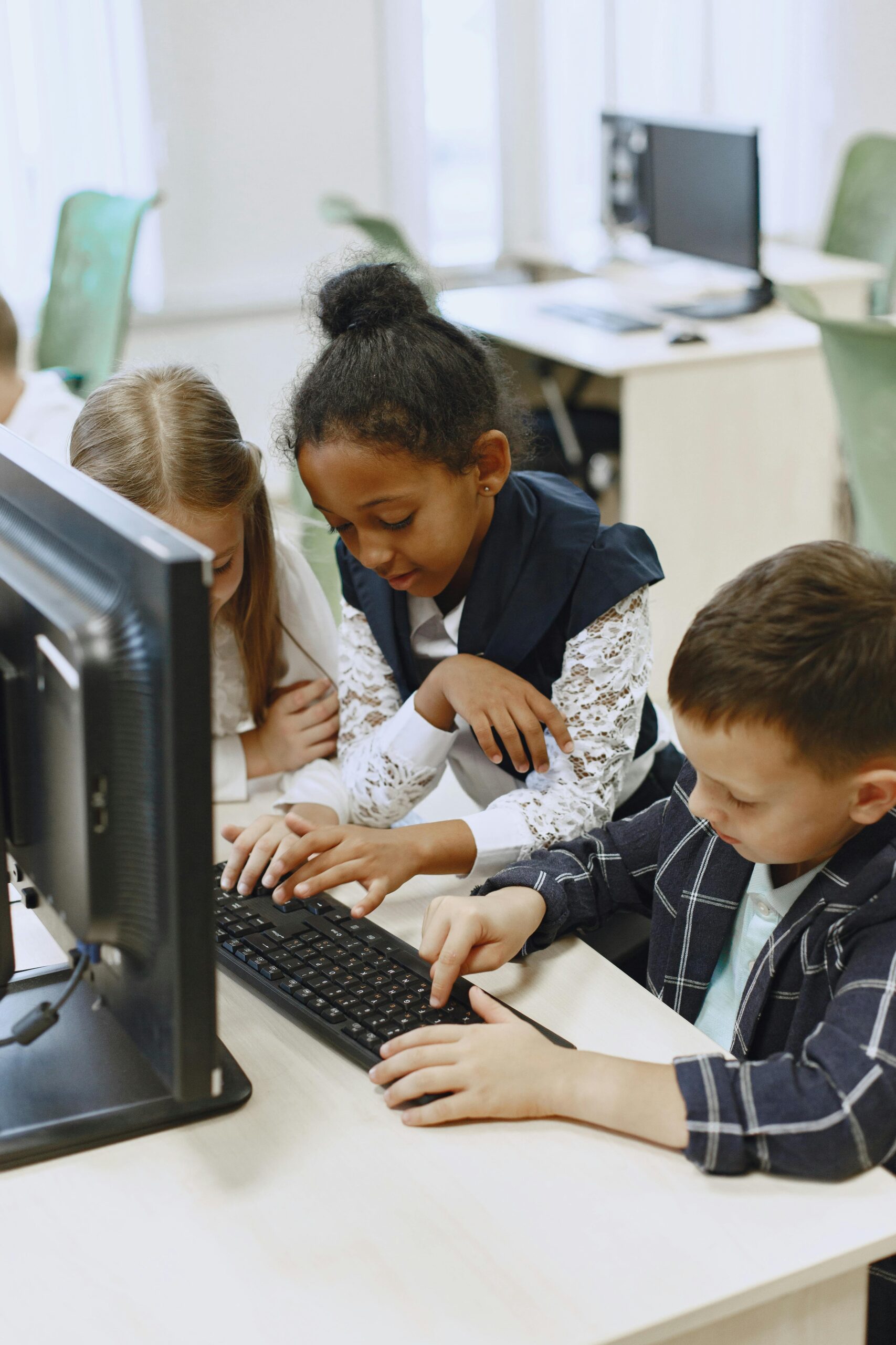 Kinder arbeiten gemeinsam an Computern in einem Klassenraum
